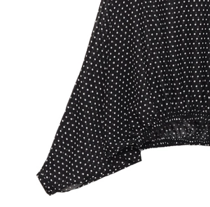 Detail of black polka dot blouse showing sheer fabric and elasticated sleeve cuffs