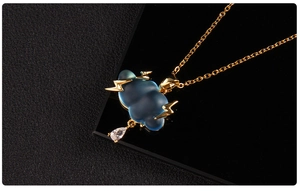 Macro view of blue cloud pendant with gold lightning and clear teardrop zircon detail