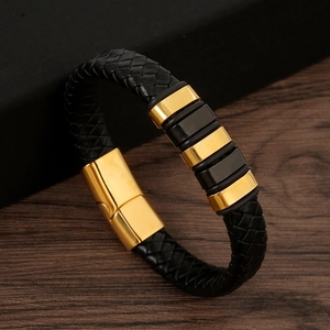 Detail of woven black leather bracelet featuring gold and black magnetic metal clasps