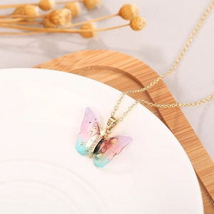 Macro detail of gradient butterfly pendant with gold plating and sparkling crystals