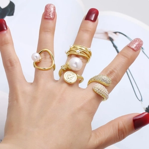 Set of 5 vintage gold-plated rings with pearls and zircon details worn by a model