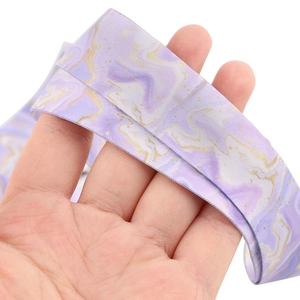 Close-up of marble pattern lanyard with purple and gold textures on soft satin fabric