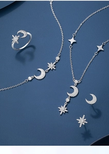 Detailed set of 925 silver star and moon jewelry with zircon stones on blue background