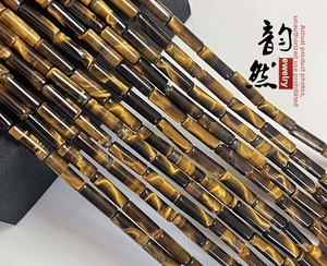 Close-up of polished natural tiger eye cylinder beads with golden cat-eye effect sheen