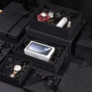 Detailed view of luxury black starlight textured gift boxes with elegant ribbon and filler