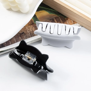 Cute cat-shaped hair claw clips in matte black and white showing strong metal spring detail