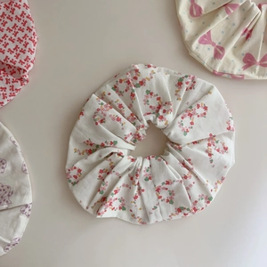 Detail shot of soft cotton floral hair scrunchies with elegant pleats and red flower patterns