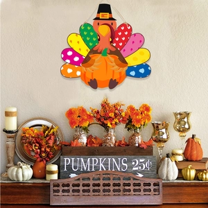 Detail view of colorful turkey wall hanging with autumn pumpkins and fireplace decor