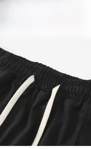 Detailed macro view of black casual trousers with elastic waistband and white cotton drawstring