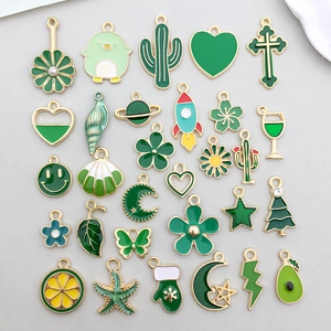 Détail d'une collection de breloques émaillées vertes pour la création de bijoux DIY