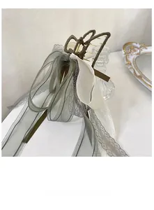 Detail of elegant large bow hair claw clip with lace, organza ribbons and pearls