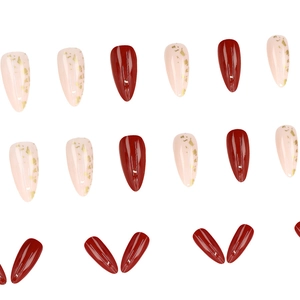 Glossy almond press-on nails in deep red and light pink with gold foil accents