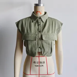 Vue détaillée du gilet court vert sauge avec boutons métalliques et poches à rabat