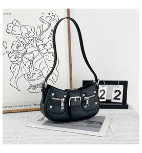 Detailed macro view of black punk style handbag with silver rivets and metal zippers