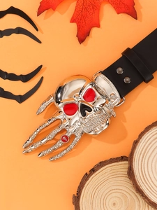 Close-up of gothic skull buckle with red eyes on a black leather belt with orange background