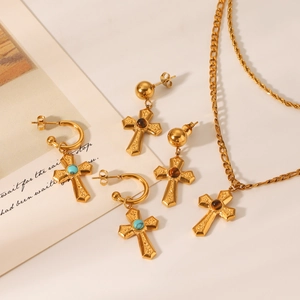 Artistic layout of gold cross jewelry set with turquoise and tiger eye stones