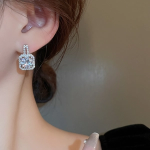Elegant square silver earrings with sparkling cubic zirconia on a female model