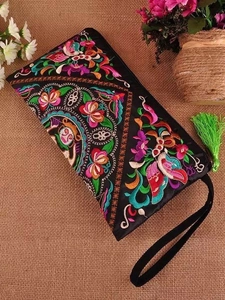 Ethnic embroidered black satin clutch bag with colorful floral patterns and green tassel