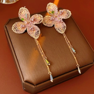 Close-up of vintage floral earrings with gold wire mesh and long beaded tassels