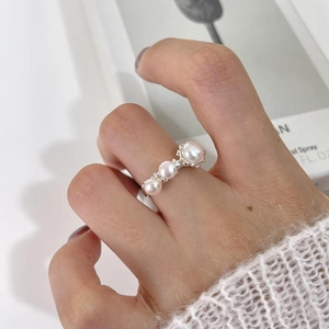 Detalle de tres perlas redondas en un anillo abierto minimalista de plata 925