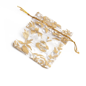 Detail of white organza drawstring pouch with elegant golden floral pattern texture