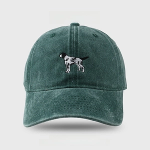 Detailed embroidery of a small dog on a vintage washed dark green cotton baseball cap