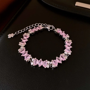 Macro detail of silver S925 bracelet with pink oval zircon and bear pendant tag