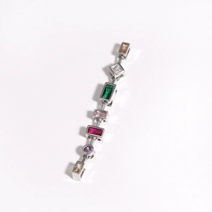 Detailed shot of silver bracelet featuring colorful rectangular and round gemstones on white