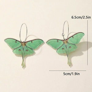 Detailed view of green Luna Moth acrylic earrings with size marks 6.5cm and 5cm