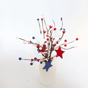 Detail of red white and blue star berry stems in a white vase for July 4th decor