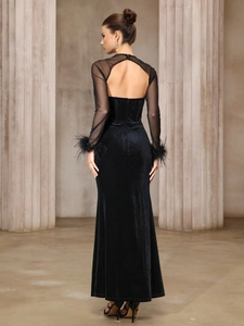 Elegant black velvet evening gown with sheer mesh sleeves and feather trim detail