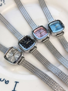 Detail of four square women's watches with silver mesh straps in multi-color dials