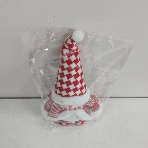 Detail showing Christmas gnome plush toy with red and white checkered hat in packaging