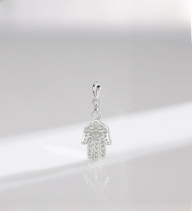 Macro detail of 925 sterling silver Hamsa hand pendant with intricate spiral carvings
