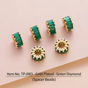 Detailed view of gold plated brass barrel spacer beads with inlaid green zircon TPJ083