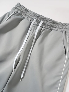 Close-up of elastic waistband with white drawstrings on grey cargo techwear pants
