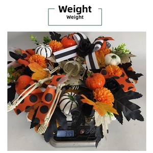Detail shot of a Halloween wreath with orange pumpkins and skulls on a scale weighing 349g