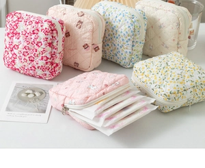 Detailed view of quilted cotton storage pouches featuring floral and bear patterns