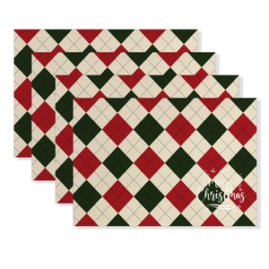 Set of four red argyle Christmas placemats with Merry Christmas text and snowflakes