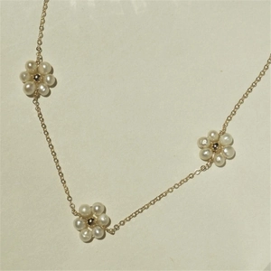 Freshwater pearl flower necklace with 14K gold plated chain on elegant beige background