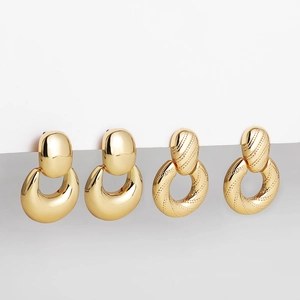 Detailed macro view of 18K gold hollow geometric ball earrings in smooth and twill textures