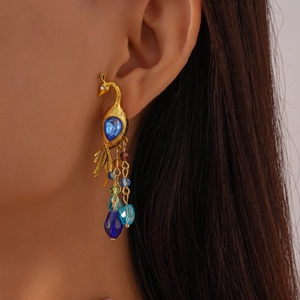 Vintage golden peacock earrings with blue crystal and colorful beaded tassels on model