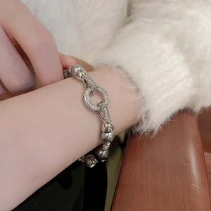 Nahaufnahme unregelmäßiger grauer Perlen und Zirkon-Verschluss eines eleganten Armbands