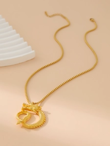 Macro detail of golden Chinese dragon pendant with intricate scales and box chain