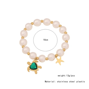 Detail view of turtle and starfish charms on a pearl bead stainless steel bracelet