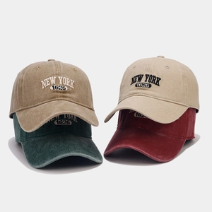 Detail of embroidered New York 1625 letters on four washed cotton baseball cap colors