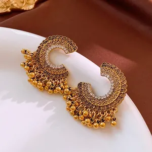 Vintage gold-tone C-shaped earrings with intricate filigree patterns and small tassels