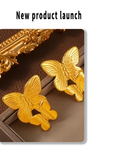 Macro shot of double-layered golden butterfly stud earrings with brushed metal texture