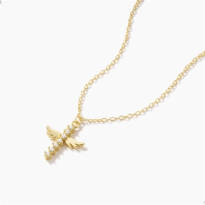Macro detail of golden angel wing cross pendant with sparkling zircon stone inlay