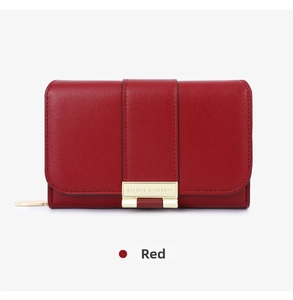 Detail of red faux leather wallet with gold metal buckle and classic modern engraving